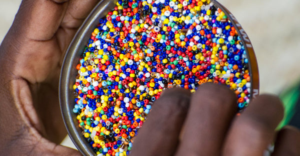 RoHo - A hand near a bowl full of colorful beads