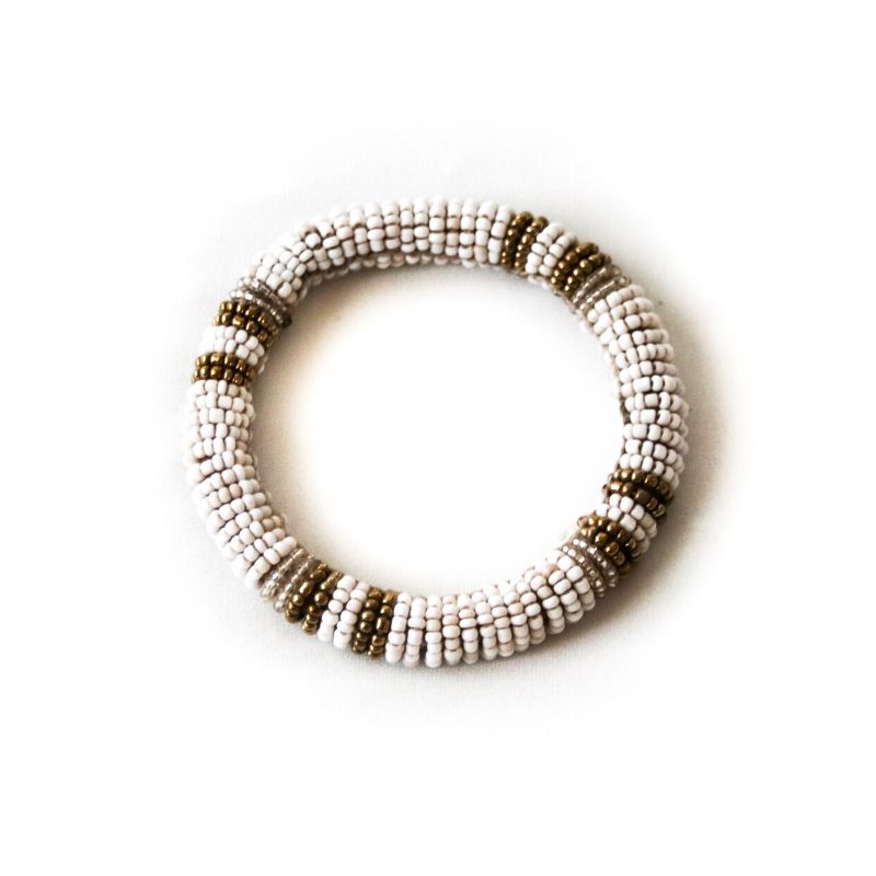A single Fair Trade RoHo handmade white beaded bangle bracelet with gold accents on a white background