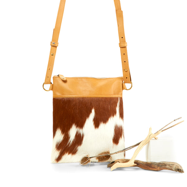Close up of RoHo's Handmade, Minimalist & Unique Tan & White Cowhide Small Crossbody Pouch, Made in Africa