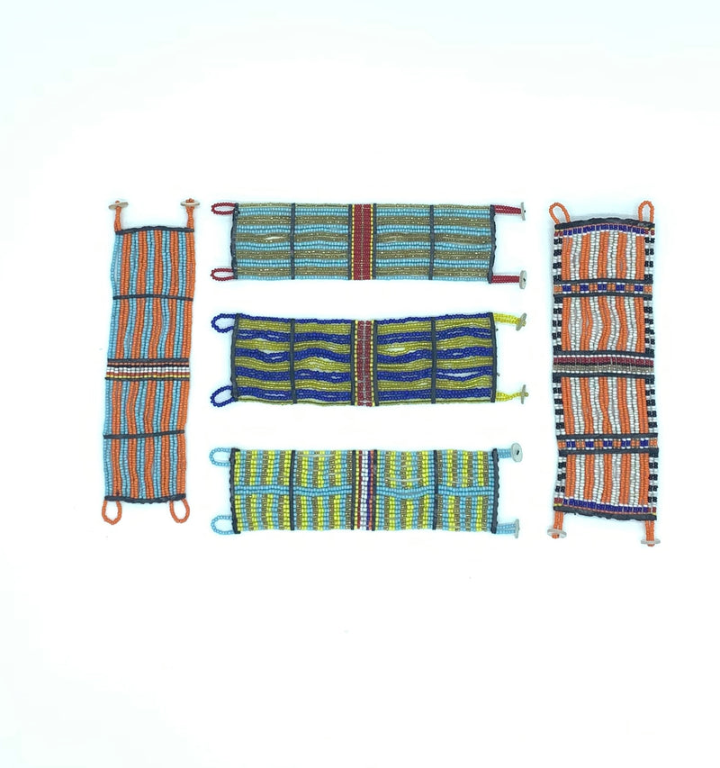 Several Kenyan beaded cuffs laid flat on a white background