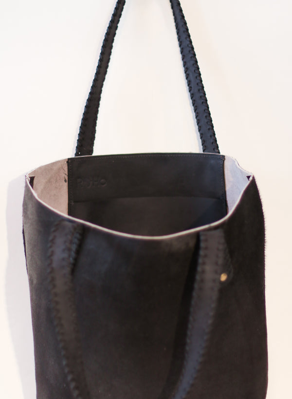 The inside pocket of a unique RoHo black cowhide tote bag with black handles