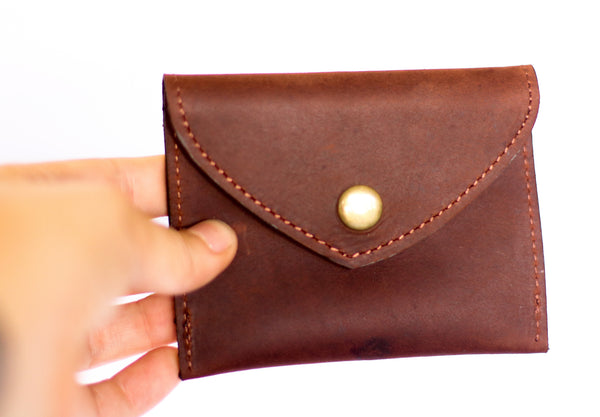A meaningful finished brown leather coin purse by RoHo that creates impact being held by a model