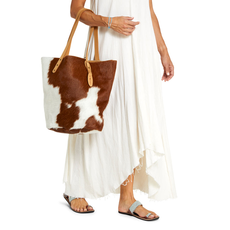 A model carrying a light brown and white hair on tote bag for women who travel