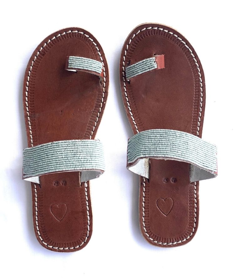 A pair of meaningful RoHo grey blue Kenyan beaded leather sandals, the Mkali sandal, on a white background