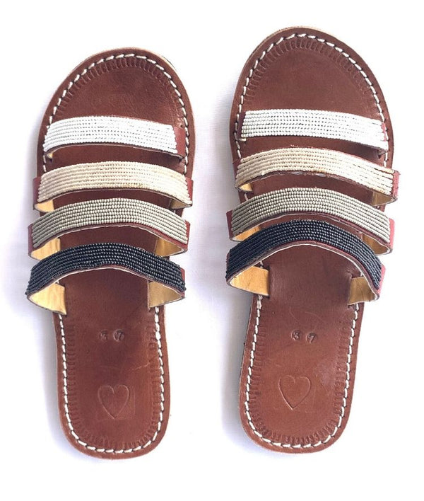 A pair of beaded RoHo leather Kenyan sandals on a white background with four straps