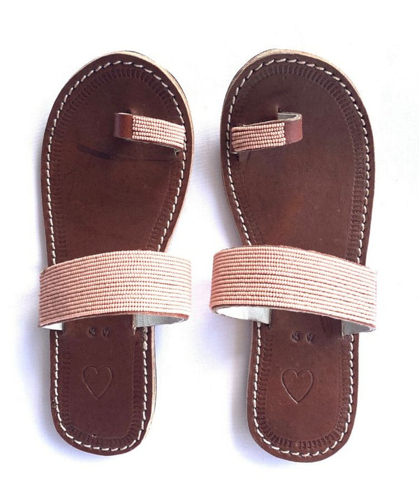 A pair of ethical dusty rose Kenyan beaded leather sandals, RoHo's Mkali sandal, on a white background