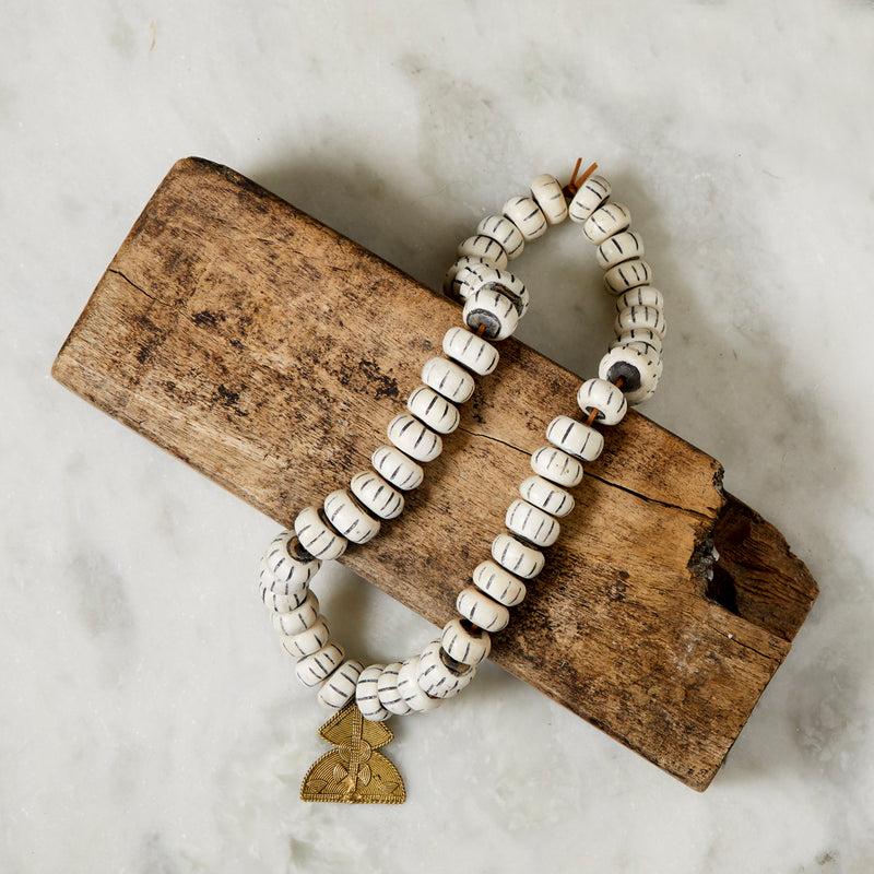 RoHo Asili Carved Fair Trade Cow Bone Beads With Pendant On a Piece of Wood