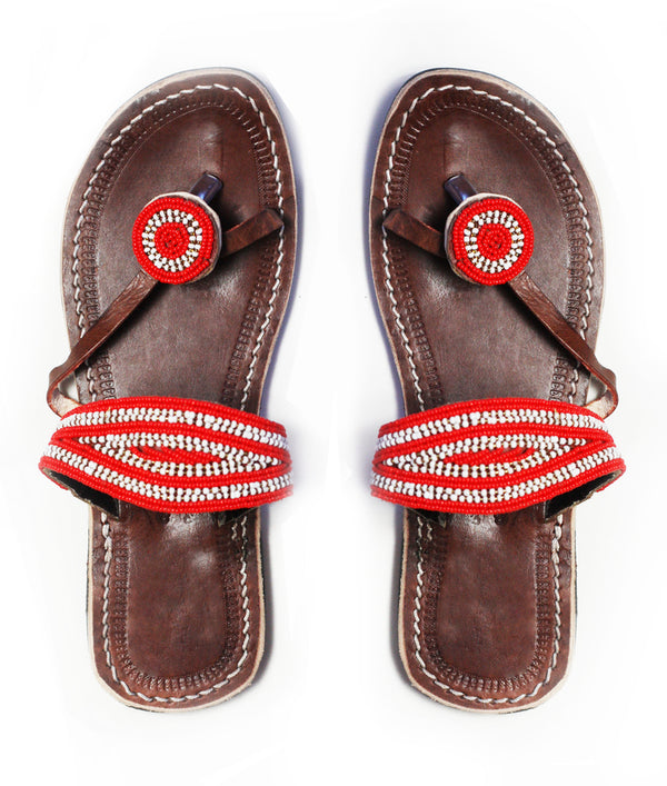 A pair of red and white ethical African beaded leather sandals, RoHo's Rafiki sandal, on a white background