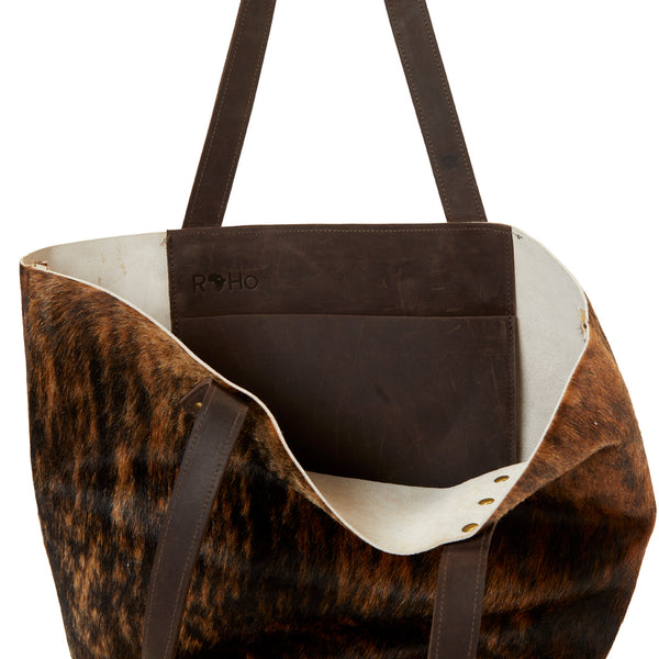 The inside of RoHo's Handcrafted Brindle Cowhide Tote Bag Handcrafted in Kenya with Leather Straps & Gold Brass Button Accents