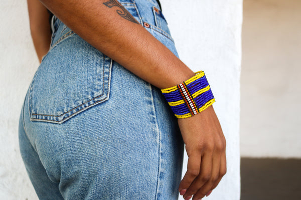 An ethical blue and yellow cuff on a model